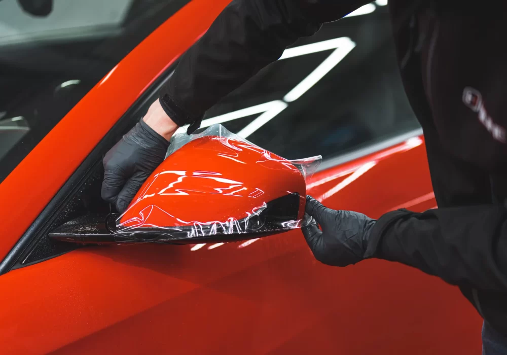 car-specialist-applying-vinyl-wrap-mirror-protect-it-from-painting-repair-shop